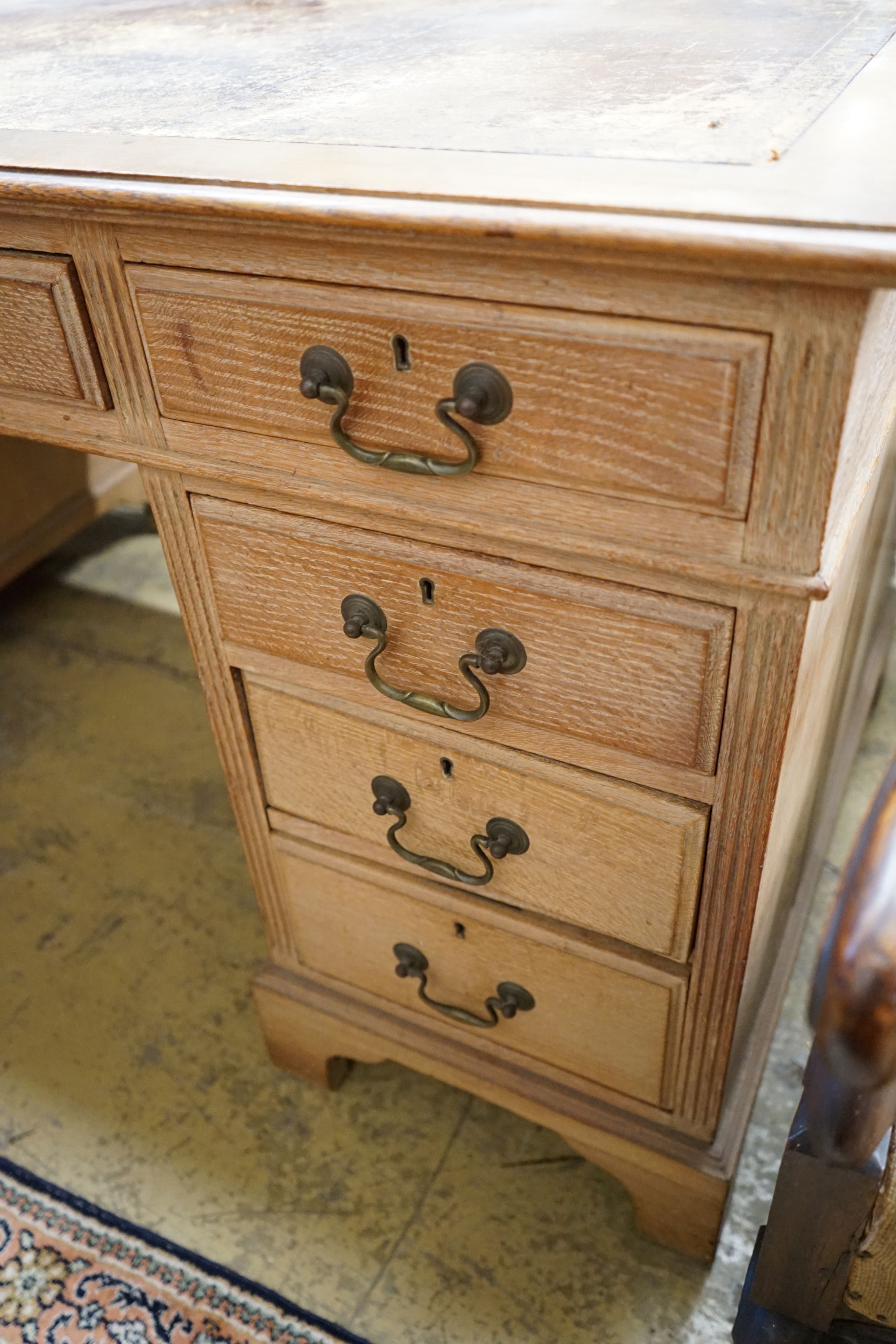 An early 20th century faded oak pedestal desk, length 153cm, depth 80cm, height 77cm